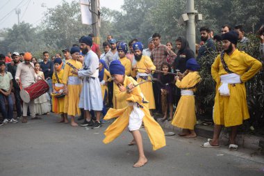 Delhi, Hindistan, 17 Kasım 2024 - Doğu Delhi bölgesinde Guru Nanak Dev, Nagar Kirtan 'ın doğum günü dolayısıyla geleneksel Nagar Kirtan, geleneksel Nagar geçit töreninde Sihler gatka ve dövüş sanatlarını sergiliyor