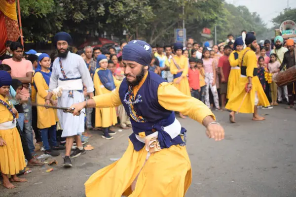 Delhi, Hindistan, 17 Kasım 2024 - Doğu Delhi bölgesinde Guru Nanak Dev, Nagar Kirtan 'ın doğum günü dolayısıyla geleneksel Nagar Kirtan, geleneksel Nagar geçit töreninde Sihler gatka ve dövüş sanatlarını sergiliyor
