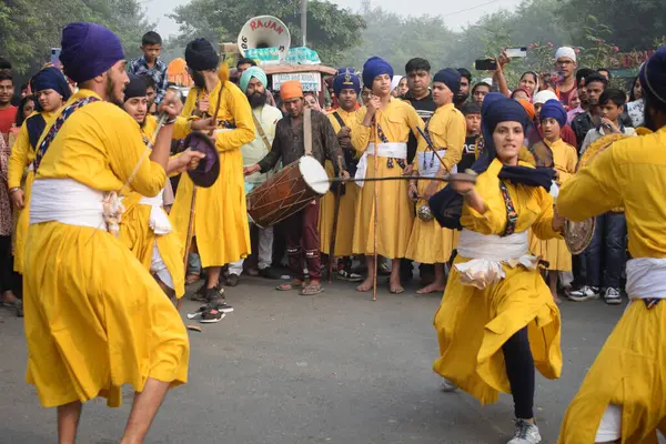 Delhi, Hindistan, 17 Kasım 2024 - Doğu Delhi bölgesinde Guru Nanak Dev, Nagar Kirtan 'ın doğum günü dolayısıyla geleneksel Nagar Kirtan, geleneksel Nagar geçit töreninde Sihler gatka ve dövüş sanatlarını sergiliyor
