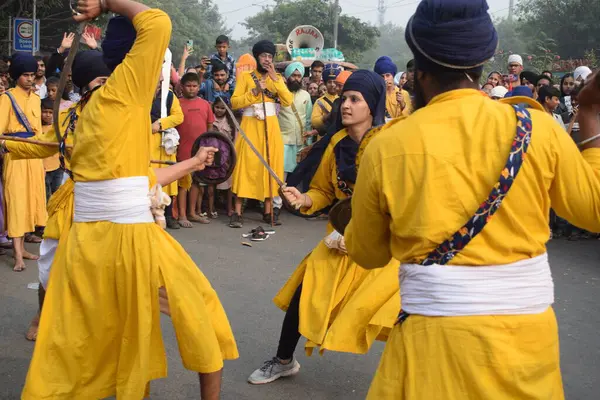 Delhi, Hindistan, 17 Kasım 2024 - Doğu Delhi bölgesinde Guru Nanak Dev, Nagar Kirtan 'ın doğum günü dolayısıyla geleneksel Nagar Kirtan, geleneksel Nagar geçit töreninde Sihler gatka ve dövüş sanatlarını sergiliyor