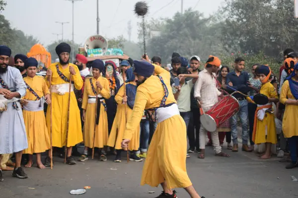 Delhi, Hindistan, 17 Kasım 2024 - Doğu Delhi bölgesinde Guru Nanak Dev, Nagar Kirtan 'ın doğum günü dolayısıyla geleneksel Nagar Kirtan, geleneksel Nagar geçit töreninde Sihler gatka ve dövüş sanatlarını sergiliyor