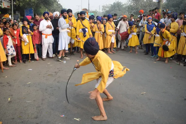 Delhi, Hindistan, 17 Kasım 2024 - Doğu Delhi bölgesinde Guru Nanak Dev, Nagar Kirtan 'ın doğum günü dolayısıyla geleneksel Nagar Kirtan, geleneksel Nagar geçit töreninde Sihler gatka ve dövüş sanatlarını sergiliyor