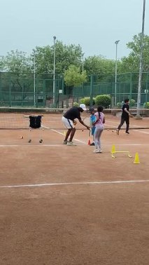 Delhi, Hindistan, 17 Şubat 2025 - Maha Open için kil tenis kortunda antrenörlük yapan genç tenisçiler, yaklaşan turnuva için küçük tenis oyuncuları antrenman yapıyor