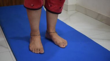 Evde yoga yapan genç Hintli bir kadın çevrimiçi yoga seansında güzel bir kız temel yoga pozisyonunda Asyalı bir kadın kapalı alanda yoga yapıyor. 