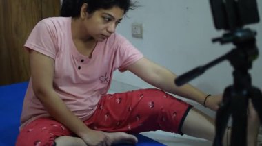 Evde yoga yapan genç Hintli bir kadın çevrimiçi yoga seansında güzel bir kız temel yoga pozisyonunda Asyalı bir kadın kapalı alanda yoga yapıyor. 