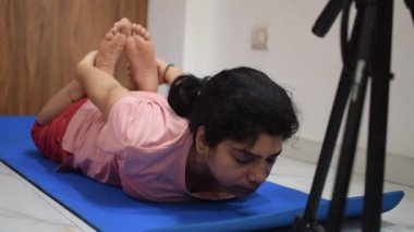 Evde yoga yapan genç Hintli bir kadın çevrimiçi yoga seansında güzel bir kız temel yoga pozisyonunda Asyalı bir kadın kapalı alanda yoga yapıyor. 