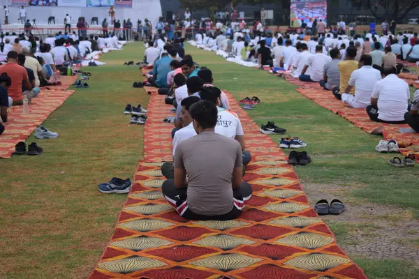 Yeni Delhi, Hindistan, 21 Haziran 2024 - Uluslararası Yoga Günü 'nde Delhi' deki Yamuna Spor Kompleksi 'nde grup Yoga egzersiz oturumu, kriket stadyumunda yoga sınıfına katılan büyük bir grup yetişkin