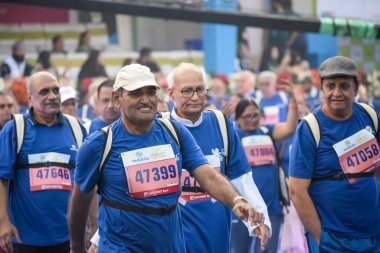 Yeni Delhi, Hindistan - 20 Ekim 2024 - Vedanta Delhi Yarı Maraton yarışına katılan yaşlılar maraton katılımcılarının bitiş çizgisini geçmek üzere oldukları Delhi Yarı Maratonu 2024