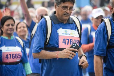 Yeni Delhi, Hindistan - 20 Ekim 2024 - Vedanta Delhi Yarı Maraton yarışına katılan yaşlılar maraton katılımcılarının bitiş çizgisini geçmek üzere oldukları Delhi Yarı Maratonu 2024