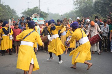 Delhi, Hindistan, 17 Kasım 2024 - Doğu Delhi bölgesinde Guru Nanak Dev, Nagar Kirtan 'ın doğum günü dolayısıyla geleneksel Nagar Kirtan, geleneksel Nagar geçit töreninde Sihler gatka ve dövüş sanatlarını sergiliyor