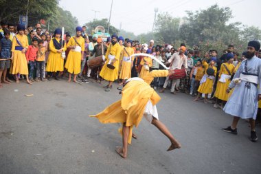 Delhi, Hindistan, 17 Kasım 2024 - Doğu Delhi bölgesinde Guru Nanak Dev, Nagar Kirtan 'ın doğum günü dolayısıyla geleneksel Nagar Kirtan, geleneksel Nagar geçit töreninde Sihler gatka ve dövüş sanatlarını sergiliyor