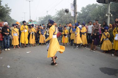 Delhi, Hindistan, 17 Kasım 2024 - Doğu Delhi bölgesinde Guru Nanak Dev, Nagar Kirtan 'ın doğum günü dolayısıyla geleneksel Nagar Kirtan, geleneksel Nagar geçit töreninde Sihler gatka ve dövüş sanatlarını sergiliyor