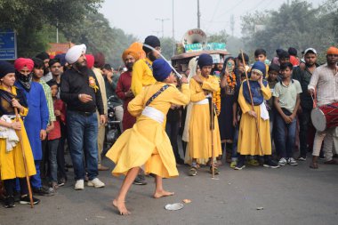 Delhi, Hindistan, 17 Kasım 2024 - Doğu Delhi bölgesinde Guru Nanak Dev, Nagar Kirtan 'ın doğum günü dolayısıyla geleneksel Nagar Kirtan, geleneksel Nagar geçit töreninde Sihler gatka ve dövüş sanatlarını sergiliyor