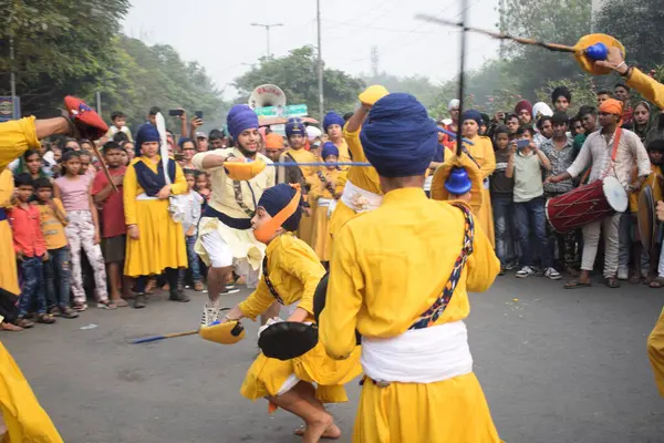 Delhi, Hindistan, 17 Kasım 2024 - Doğu Delhi bölgesinde Guru Nanak Dev, Nagar Kirtan 'ın doğum günü dolayısıyla geleneksel Nagar Kirtan, geleneksel Nagar geçit töreninde Sihler gatka ve dövüş sanatlarını sergiliyor