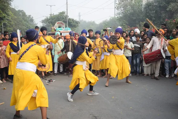 Delhi, Hindistan, 17 Kasım 2024 - Doğu Delhi bölgesinde Guru Nanak Dev, Nagar Kirtan 'ın doğum günü dolayısıyla geleneksel Nagar Kirtan, geleneksel Nagar geçit töreninde Sihler gatka ve dövüş sanatlarını sergiliyor