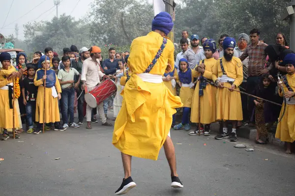 Delhi, Hindistan, 17 Kasım 2024 - Doğu Delhi bölgesinde Guru Nanak Dev, Nagar Kirtan 'ın doğum günü dolayısıyla geleneksel Nagar Kirtan, geleneksel Nagar geçit töreninde Sihler gatka ve dövüş sanatlarını sergiliyor
