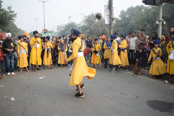 Delhi, Hindistan, 17 Kasım 2024 - Doğu Delhi bölgesinde Guru Nanak Dev, Nagar Kirtan 'ın doğum günü dolayısıyla geleneksel Nagar Kirtan, geleneksel Nagar geçit töreninde Sihler gatka ve dövüş sanatlarını sergiliyor