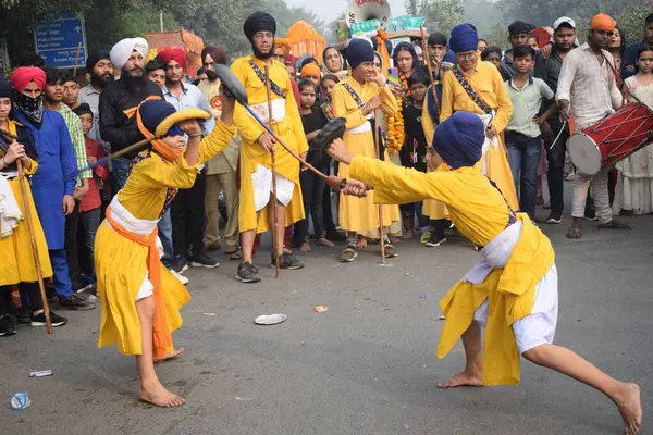 Delhi, Hindistan, 17 Kasım 2024 - Doğu Delhi bölgesinde Guru Nanak Dev, Nagar Kirtan 'ın doğum günü dolayısıyla geleneksel Nagar Kirtan, geleneksel Nagar geçit töreninde Sihler gatka ve dövüş sanatlarını sergiliyor