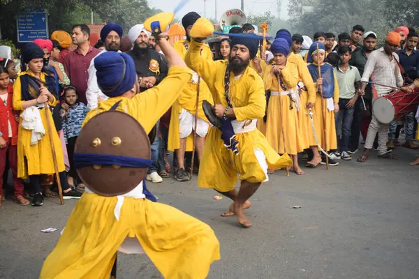 Delhi, Hindistan, 17 Kasım 2024 - Doğu Delhi bölgesinde Guru Nanak Dev, Nagar Kirtan 'ın doğum günü dolayısıyla geleneksel Nagar Kirtan, geleneksel Nagar geçit töreninde Sihler gatka ve dövüş sanatlarını sergiliyor