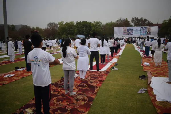 Yeni Delhi, Hindistan, 21 Haziran 2024 - Uluslararası Yoga Günü 'nde Delhi' deki Yamuna Spor Kompleksi 'nde grup Yoga egzersiz oturumu, kriket stadyumunda yoga sınıfına katılan büyük bir grup yetişkin
