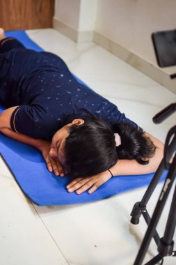 Evde yoga yapan genç Hintli bir kadın çevrimiçi yoga seansında güzel bir kız temel yoga pozisyonunda Asyalı bir kadın kapalı alanda yoga yapıyor.