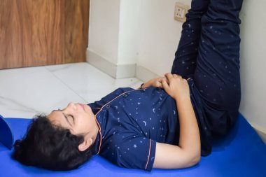 Evde yoga yapan genç Hintli bir kadın çevrimiçi yoga seansında güzel bir kız temel yoga pozisyonunda Asyalı bir kadın kapalı alanda yoga yapıyor.