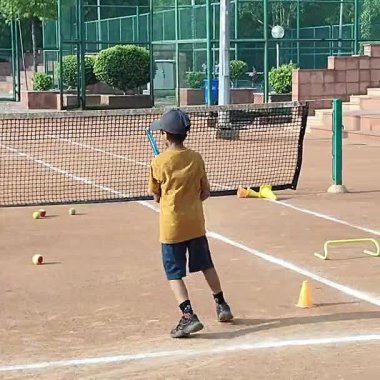 Delhi, Hindistan, 17 Şubat 2025 - Maha Open için kil tenis kortunda antrenörlük yapan genç tenisçiler, yaklaşan turnuva için küçük tenis oyuncuları antrenman yapıyor