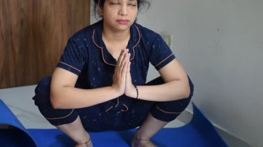Evde yoga yapan genç Hintli bir kadın çevrimiçi yoga seansında güzel bir kız temel yoga pozisyonunda Asyalı bir kadın kapalı alanda yoga yapıyor. 