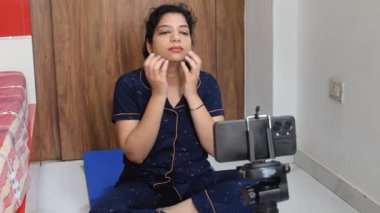 Evde yoga yapan genç Hintli bir kadın çevrimiçi yoga seansında güzel bir kız temel yoga pozisyonunda Asyalı bir kadın kapalı alanda yoga yapıyor. 