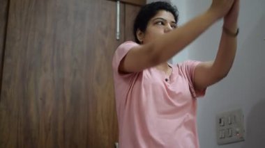 Evde yoga yapan genç Hintli bir kadın çevrimiçi yoga seansında güzel bir kız temel yoga pozisyonunda Asyalı bir kadın kapalı alanda yoga yapıyor. 