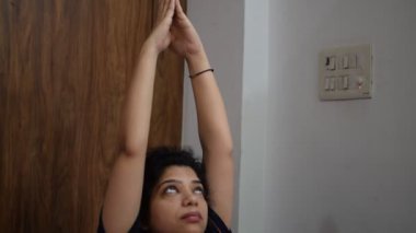 Evde yoga yapan genç Hintli bir kadın çevrimiçi yoga seansında güzel bir kız temel yoga pozisyonunda Asyalı bir kadın kapalı alanda yoga yapıyor. 