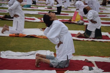 Yeni Delhi, Hindistan, 21 Haziran 2024 - Uluslararası Yoga Günü 'nde Delhi' deki Yamuna Spor Kompleksi 'nde grup Yoga egzersiz oturumu, kriket stadyumunda yoga sınıfına katılan büyük bir grup yetişkin
