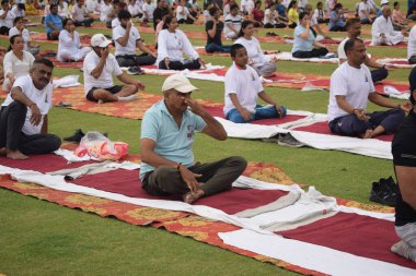 Yeni Delhi, Hindistan, 21 Haziran 2024 - Uluslararası Yoga Günü 'nde Delhi' deki Yamuna Spor Kompleksi 'nde grup Yoga egzersiz oturumu, kriket stadyumunda yoga sınıfına katılan büyük bir grup yetişkin
