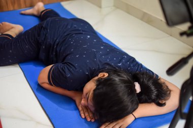 Evde yoga yapan genç Hintli bir kadın çevrimiçi yoga seansında güzel bir kız temel yoga pozisyonunda Asyalı bir kadın kapalı alanda yoga yapıyor.