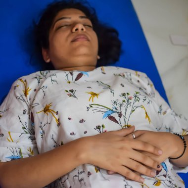 Evde yoga yapan genç Hintli bir kadın çevrimiçi yoga seansında güzel bir kız temel yoga pozisyonunda Asyalı bir kadın kapalı alanda yoga yapıyor.