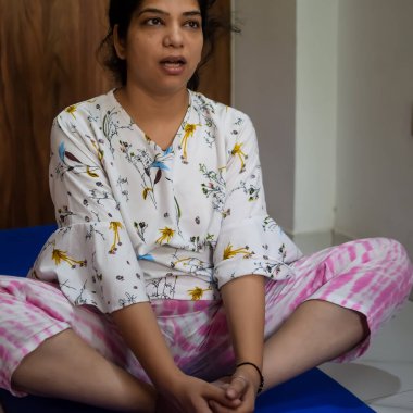 Evde yoga yapan genç Hintli bir kadın çevrimiçi yoga seansında güzel bir kız temel yoga pozisyonunda Asyalı bir kadın kapalı alanda yoga yapıyor.