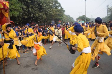 Delhi, Hindistan, 17 Kasım 2024 - Doğu Delhi bölgesinde Guru Nanak Dev, Nagar Kirtan 'ın doğum günü dolayısıyla geleneksel Nagar Kirtan, geleneksel Nagar geçit töreninde Sihler gatka ve dövüş sanatlarını sergiliyor