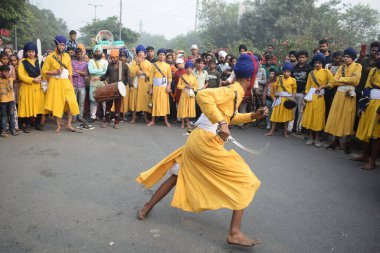Delhi, Hindistan, 17 Kasım 2024 - Doğu Delhi bölgesinde Guru Nanak Dev, Nagar Kirtan 'ın doğum günü dolayısıyla geleneksel Nagar Kirtan, geleneksel Nagar geçit töreninde Sihler gatka ve dövüş sanatlarını sergiliyor
