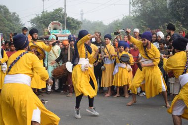 Delhi, Hindistan, 17 Kasım 2024 - Doğu Delhi bölgesinde Guru Nanak Dev, Nagar Kirtan 'ın doğum günü dolayısıyla geleneksel Nagar Kirtan, geleneksel Nagar geçit töreninde Sihler gatka ve dövüş sanatlarını sergiliyor