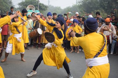 Delhi, Hindistan, 17 Kasım 2024 - Doğu Delhi bölgesinde Guru Nanak Dev, Nagar Kirtan 'ın doğum günü dolayısıyla geleneksel Nagar Kirtan, geleneksel Nagar geçit töreninde Sihler gatka ve dövüş sanatlarını sergiliyor
