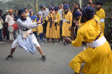 Delhi, Hindistan, 17 Kasım 2024 - Doğu Delhi bölgesinde Guru Nanak Dev, Nagar Kirtan 'ın doğum günü dolayısıyla geleneksel Nagar Kirtan, geleneksel Nagar geçit töreninde Sihler gatka ve dövüş sanatlarını sergiliyor