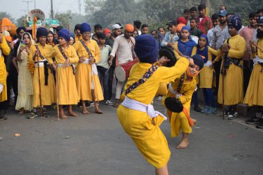 Delhi, Hindistan, 17 Kasım 2024 - Doğu Delhi bölgesinde Guru Nanak Dev, Nagar Kirtan 'ın doğum günü dolayısıyla geleneksel Nagar Kirtan, geleneksel Nagar geçit töreninde Sihler gatka ve dövüş sanatlarını sergiliyor