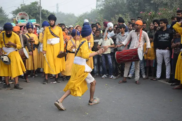 Delhi, Hindistan, 17 Kasım 2024 - Doğu Delhi bölgesinde Guru Nanak Dev, Nagar Kirtan 'ın doğum günü dolayısıyla geleneksel Nagar Kirtan, geleneksel Nagar geçit töreninde Sihler gatka ve dövüş sanatlarını sergiliyor