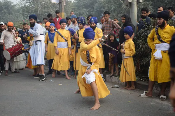 Delhi, Hindistan, 17 Kasım 2024 - Doğu Delhi bölgesinde Guru Nanak Dev, Nagar Kirtan 'ın doğum günü dolayısıyla geleneksel Nagar Kirtan, geleneksel Nagar geçit töreninde Sihler gatka ve dövüş sanatlarını sergiliyor