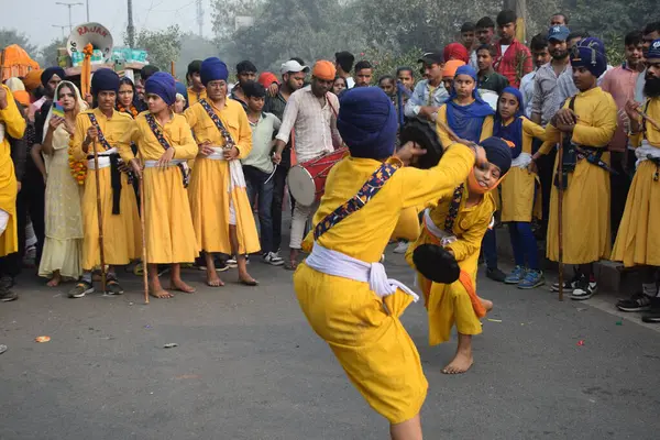 Delhi, Hindistan, 17 Kasım 2024 - Doğu Delhi bölgesinde Guru Nanak Dev, Nagar Kirtan 'ın doğum günü dolayısıyla geleneksel Nagar Kirtan, geleneksel Nagar geçit töreninde Sihler gatka ve dövüş sanatlarını sergiliyor