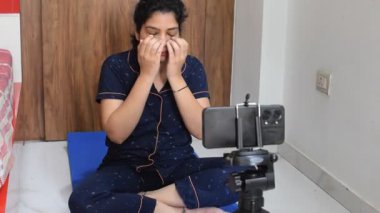 Evde yoga yapan genç Hintli bir kadın çevrimiçi yoga seansında güzel bir kız temel yoga pozisyonunda Asyalı bir kadın kapalı alanda yoga yapıyor. 