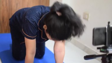 Evde yoga yapan genç Hintli bir kadın çevrimiçi yoga seansında güzel bir kız temel yoga pozisyonunda Asyalı bir kadın kapalı alanda yoga yapıyor. 