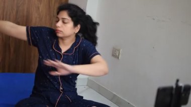 Evde yoga yapan genç Hintli bir kadın çevrimiçi yoga seansında güzel bir kız temel yoga pozisyonunda Asyalı bir kadın kapalı alanda yoga yapıyor. 