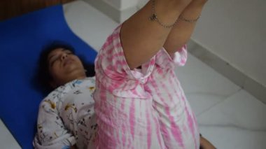 Evde yoga yapan genç Hintli bir kadın çevrimiçi yoga seansında güzel bir kız temel yoga pozisyonunda Asyalı bir kadın kapalı alanda yoga yapıyor. 