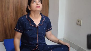 Evde yoga yapan genç Hintli bir kadın çevrimiçi yoga seansında güzel bir kız temel yoga pozisyonunda Asyalı bir kadın kapalı alanda yoga yapıyor. 